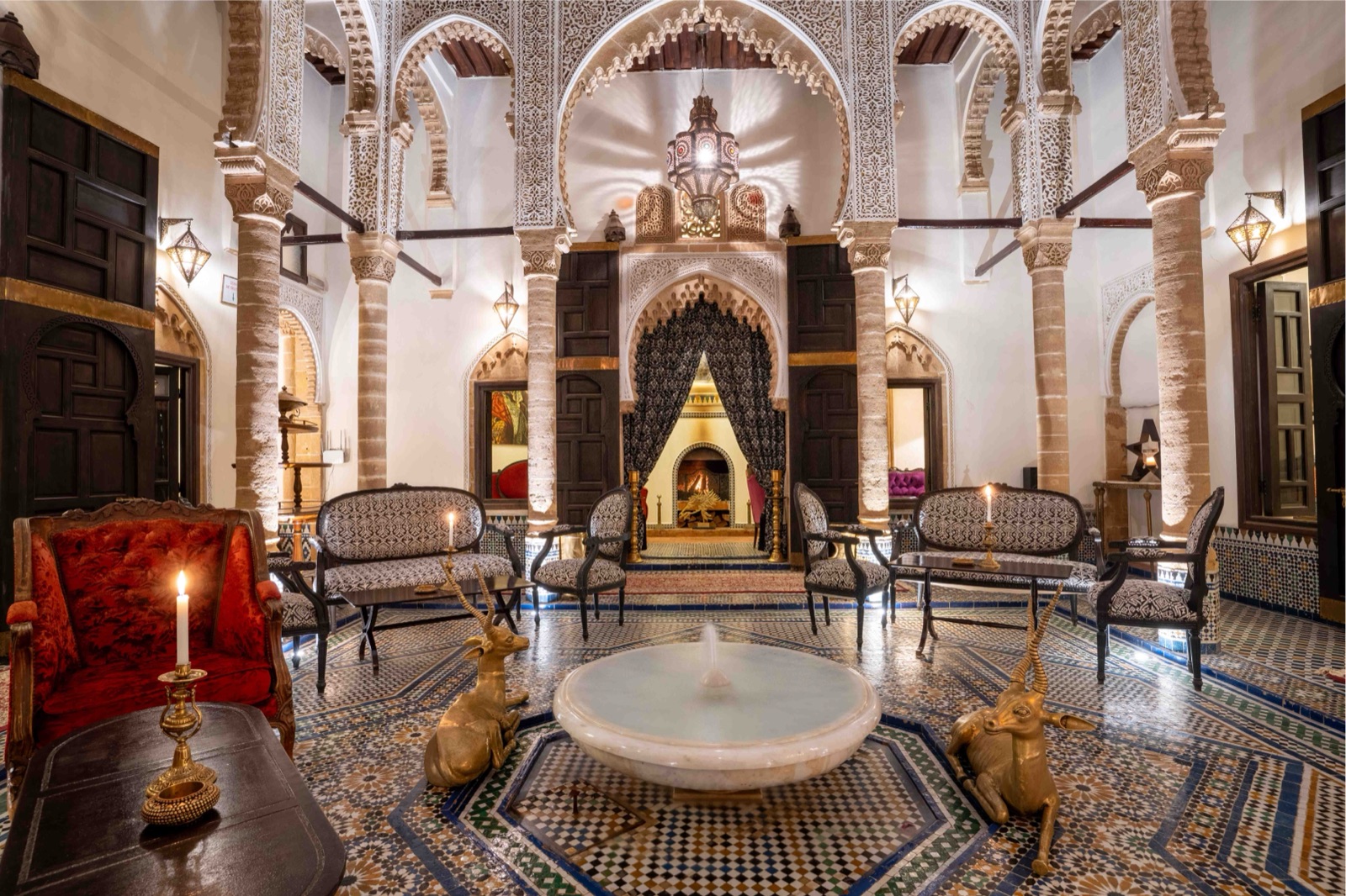 Le patio du Riad Thamayna : fontaine de marbre, sol en zellige, arcs de stuc ciselé et lanterne, éclairés aux bougies