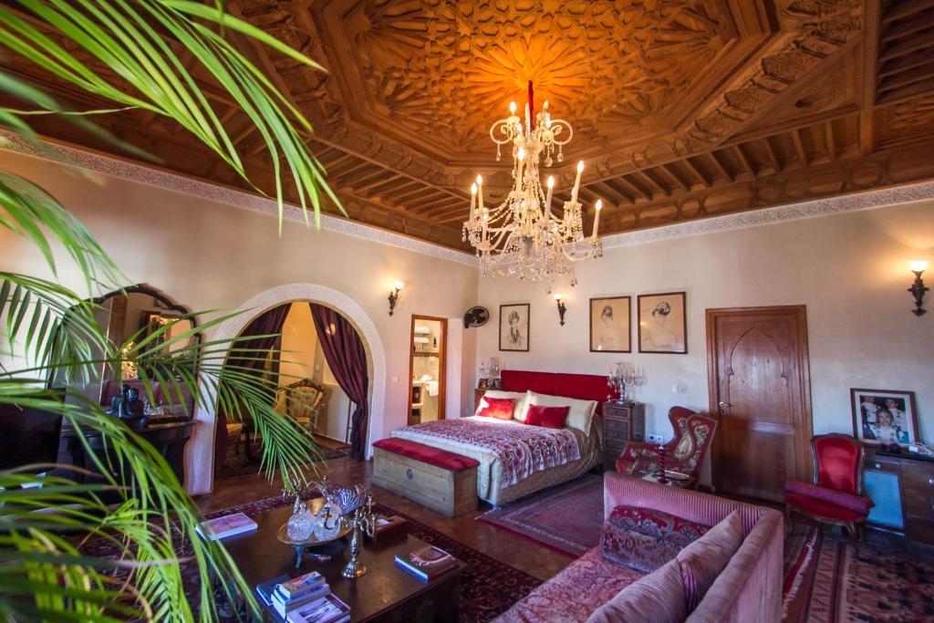 Suite Sultana : plafond de bois sculpté, lustre de cristal et lit à tête rouge